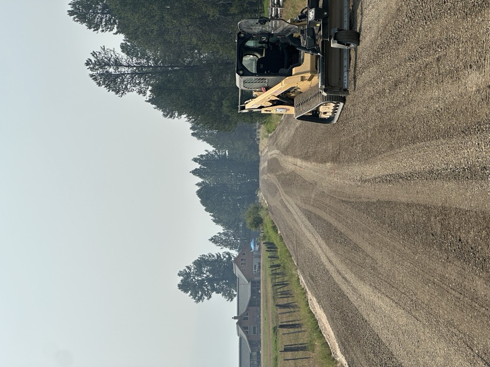 Track loader grading a gravel county road