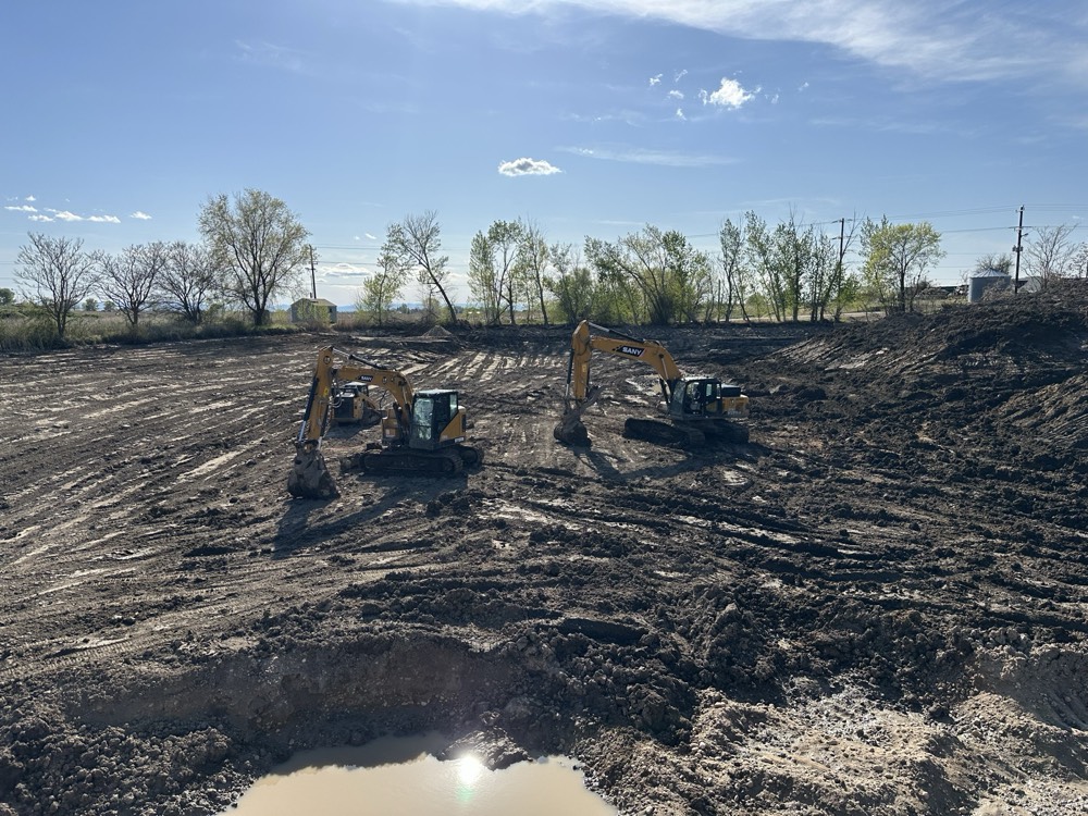 Two excavators digging a large pond